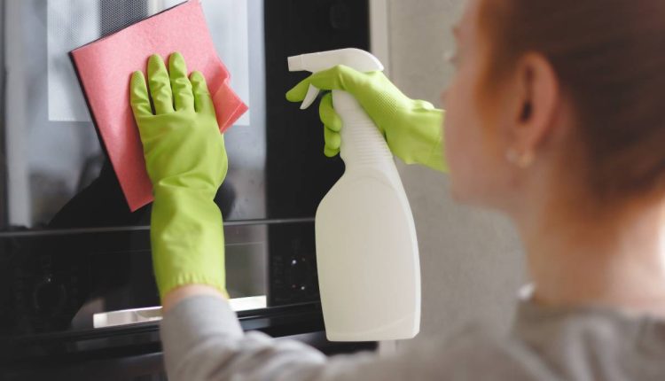 femme qui nettoie son micro-ondes